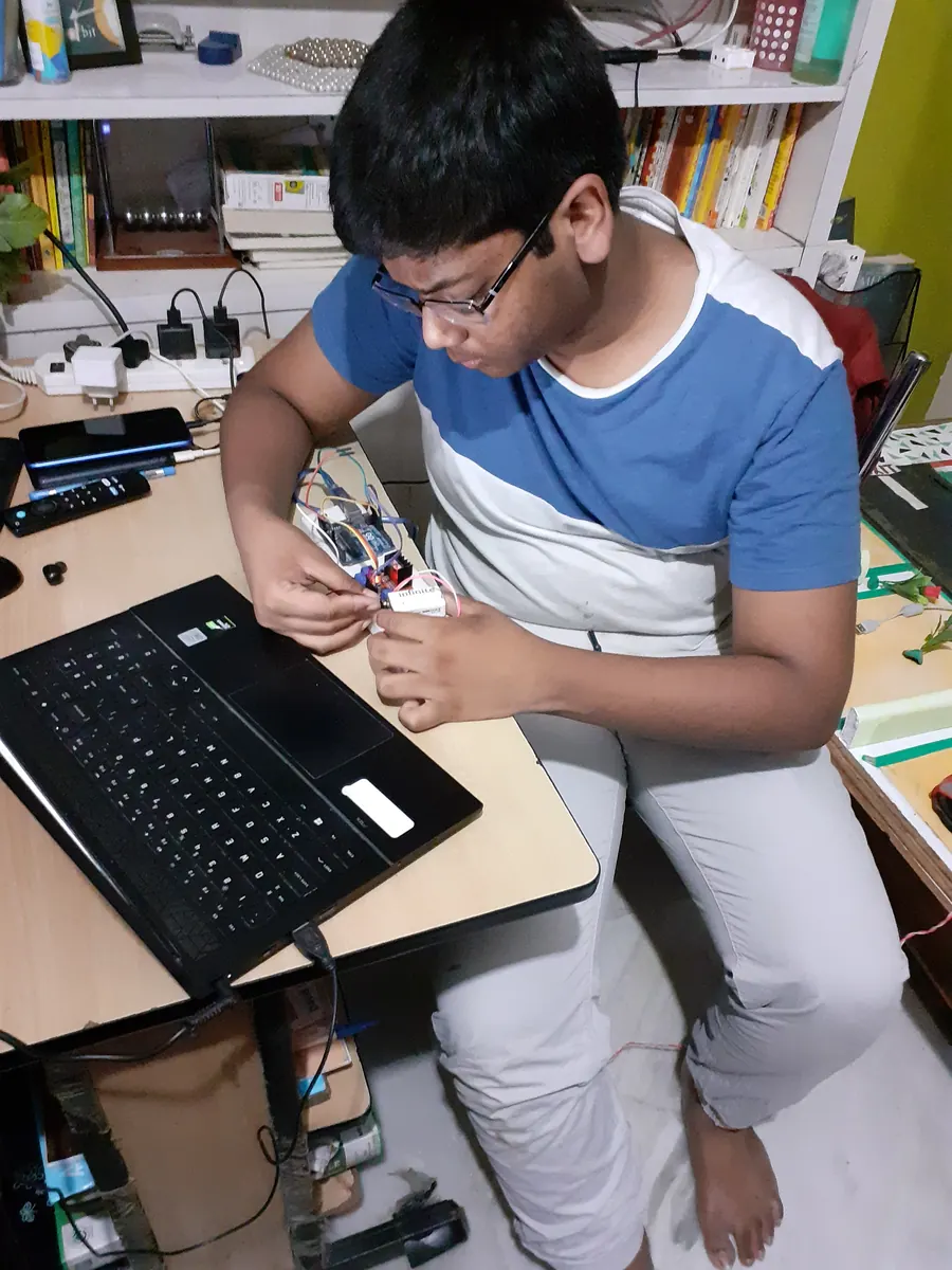 Akshit at his desk wiring an electronics project